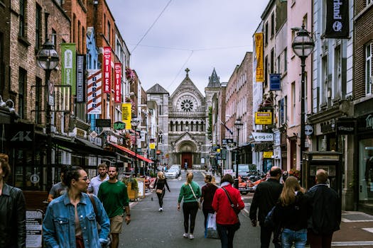 A bustling street scene in Dublin, showcasing diverse people and historic architecture.