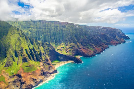 Discover the stunning aerial view of Na Pali Coast in Kauai, showcasing cliffs and turquoise waters.