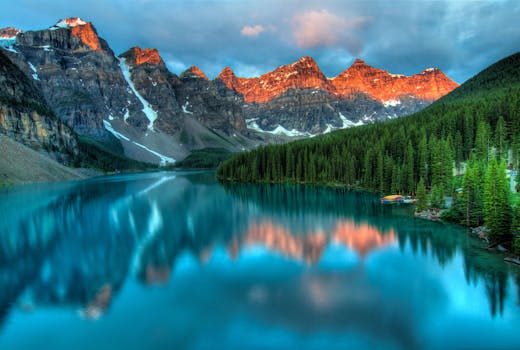 Capture the serene beauty of Moraine Lake with sunrise reflections in Banff National Park.