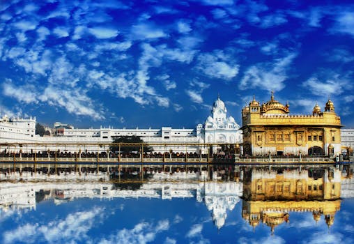 The Golden Temple, Harmandir Sahib, in Amritsar beautifully reflected in water with a vivid blue sky.