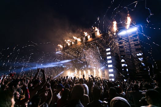 Vibrant concert scene with crowd enjoying night festival and dynamic stage fireworks.