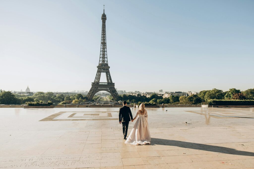 A bride and groom sharing a romantic moment in front of the iconic Eiffel Tower in Paris.